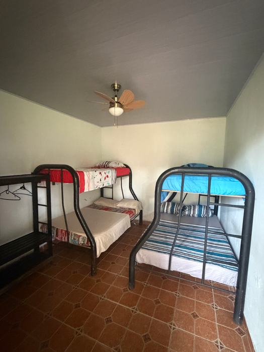 Habitación con dos camarotes, ventilador de techo y piso de baldosa
